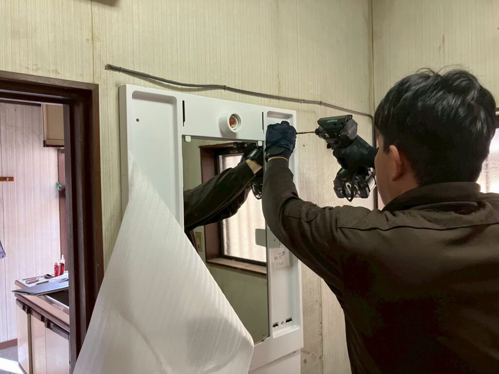 新しい洗面台の上台を取り付けている様子